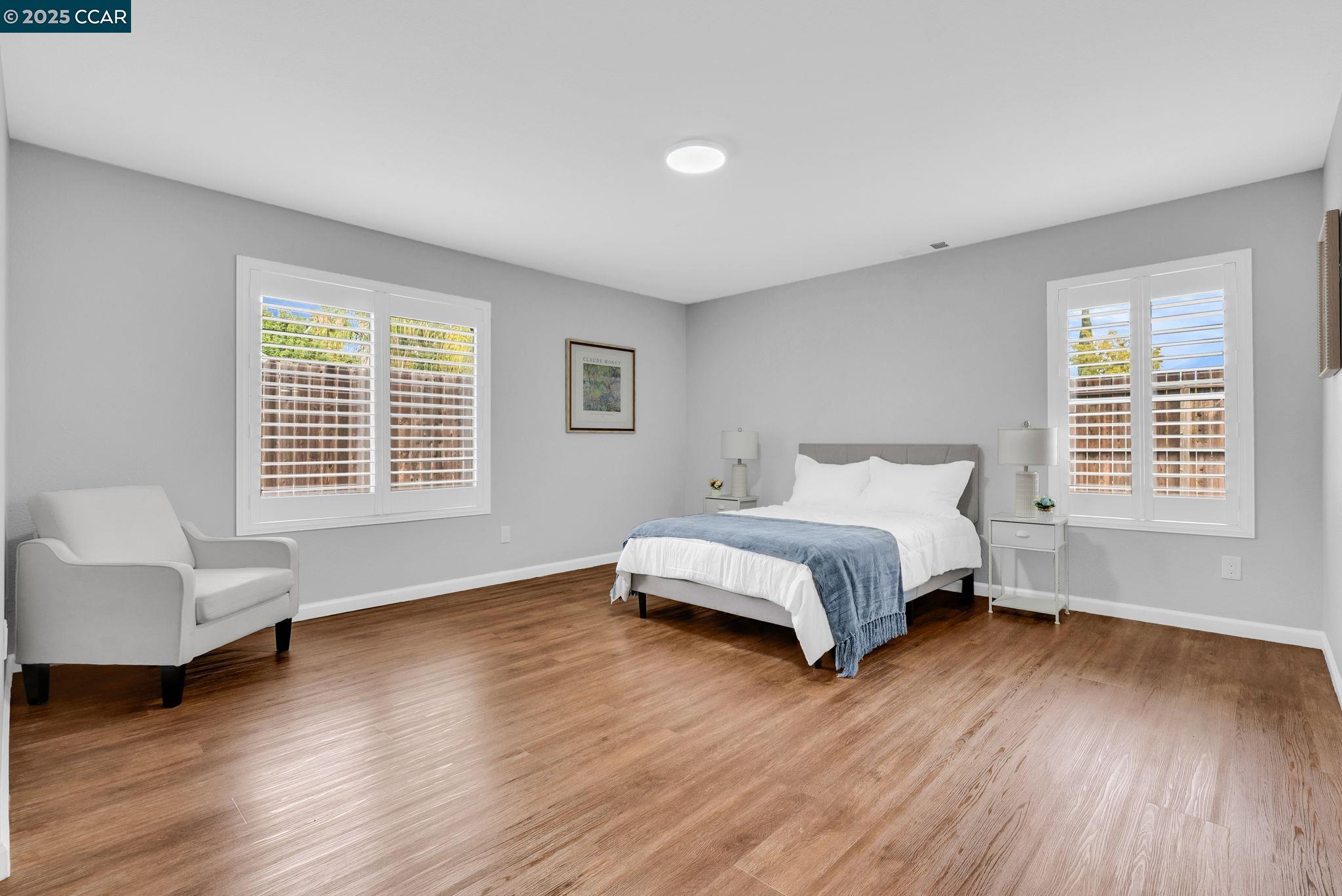 432 Red Robin Drive Patterson, CA 95363 - Photo 35 of 47 a spacious bedroom with a bed and a couch with wooden floor