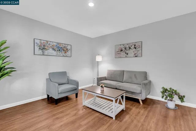 a living room with furniture and a wooden floor