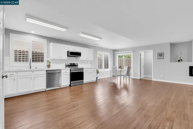 a view of a kitchen with a sink stove cabinets and empty room
