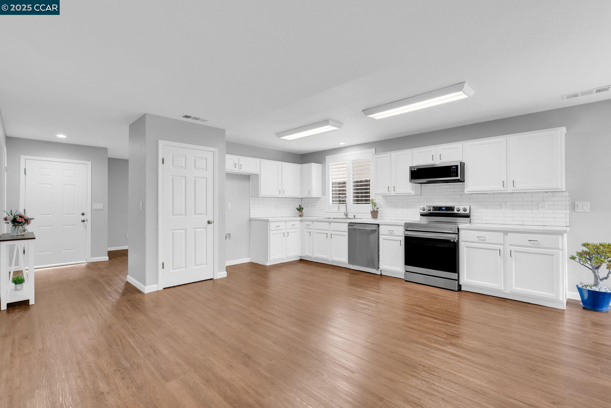 432 Red Robin Drive Patterson, CA 95363 - Photo 9 of 47 a large white kitchen with stainless steel appliances