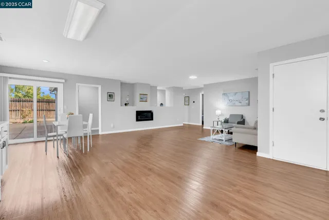 a view of empty room with wooden floor and window