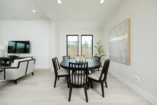 a living room with furniture a flat screen tv and kitchen view