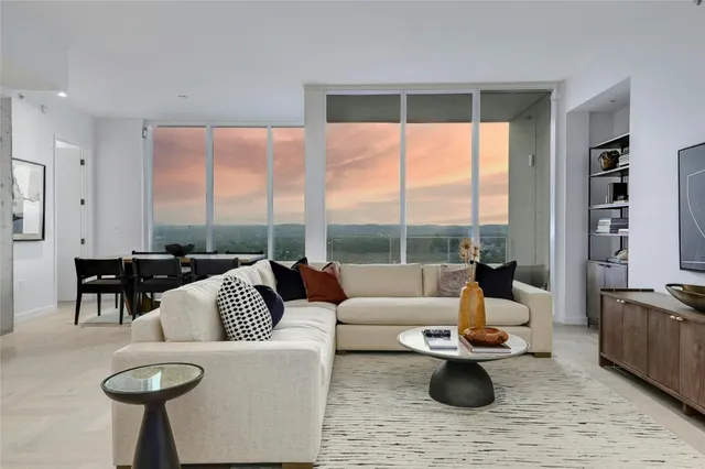 a living room with furniture wooden floor and a large window