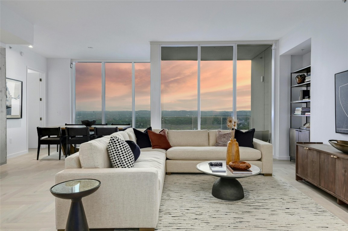 a living room with furniture wooden floor and a large window