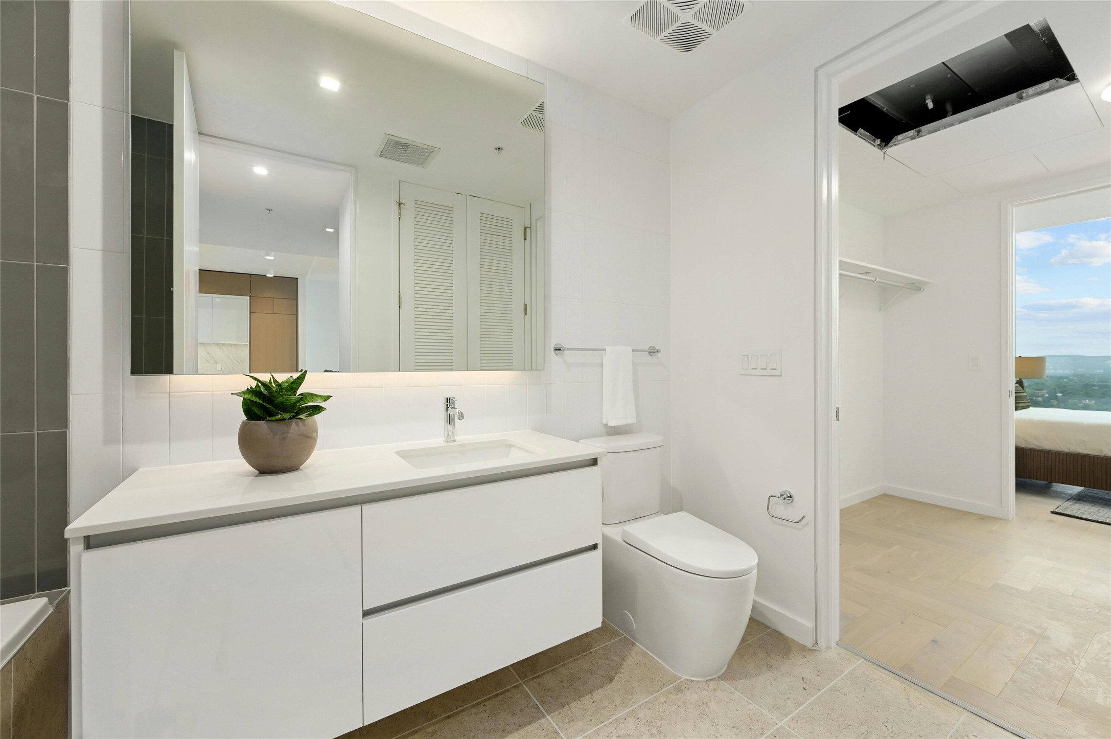 313 West 17th Street, Unit 2204 Austin, TX 78701 - Photo 18 of 40 Full secondary bathroom featuring a sleek floating vanity, integrated storage, and modern fixtures, conveniently connected to the adjacent bedroom and walk-in closet.