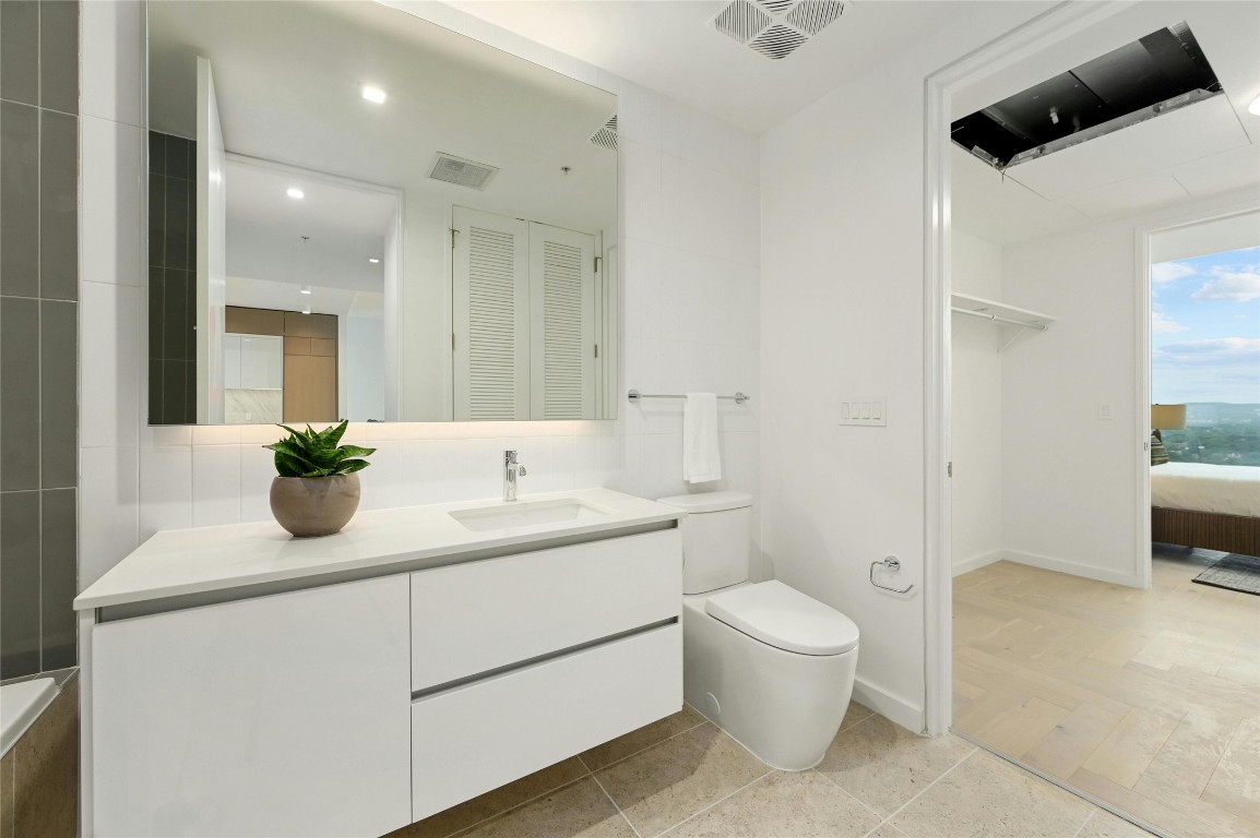 313 West 17th Street, Unit 2204 Austin, TX 78701 - Photo 18 of 40 a bathroom with a toilet a sink and a mirror