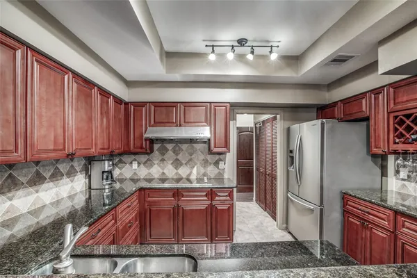 a kitchen with stainless steel appliances granite countertop a refrigerator and a sink
