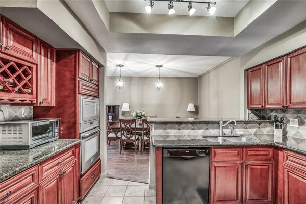 a kitchen with stainless steel appliances granite countertop a stove a sink and a microwave