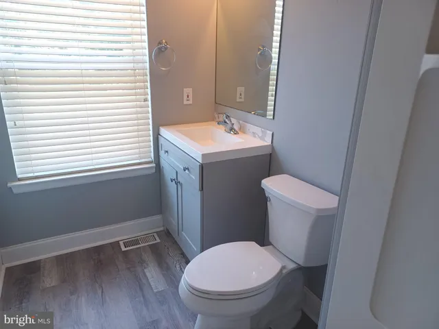 a bathroom with a toilet and a mirror