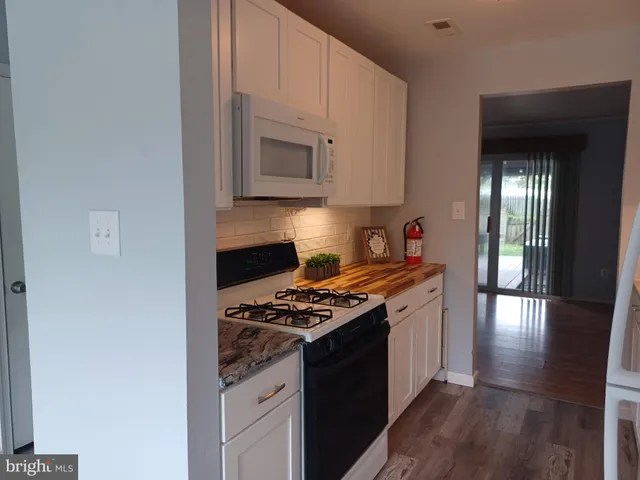 a kitchen with stainless steel appliances granite countertop a stove and a white cabinets