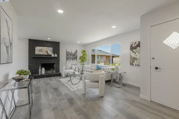 a living room with furniture large window and fireplace