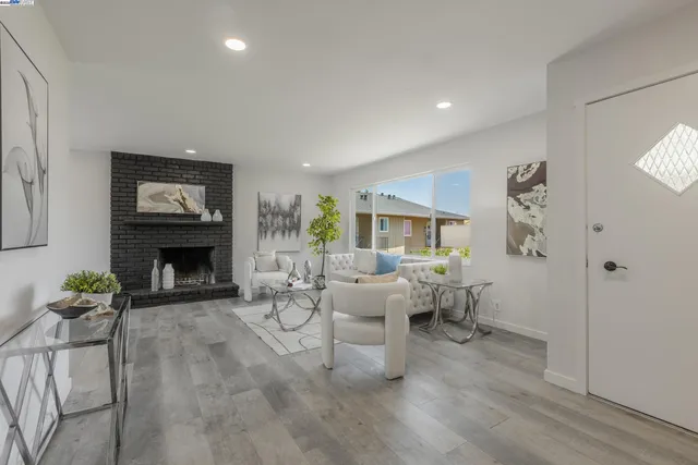 a living room with furniture large window and fireplace