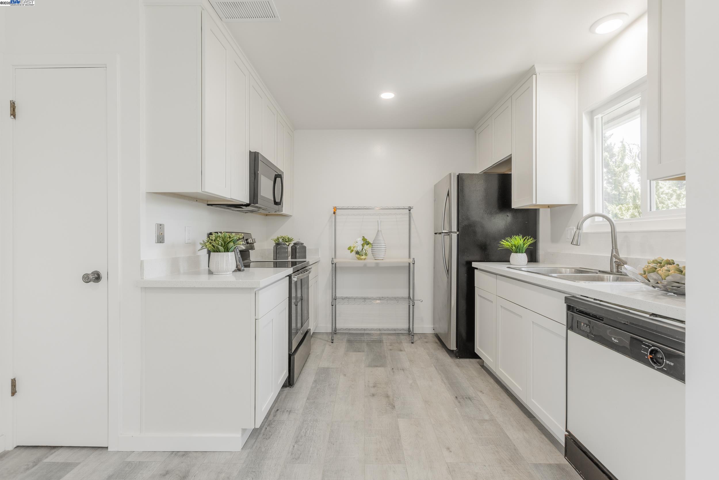 1965 Ascot Drive, Unit 6 Moraga, CA 94556 - Photo 4 of 25 a kitchen with stainless steel appliances a refrigerator sink and white cabinets
