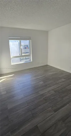 a view of room with wooden floor and window