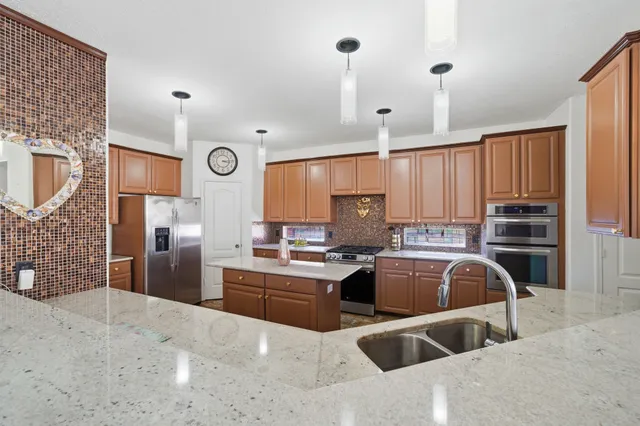 a kitchen with stainless steel appliances a sink a stove and a refrigerator