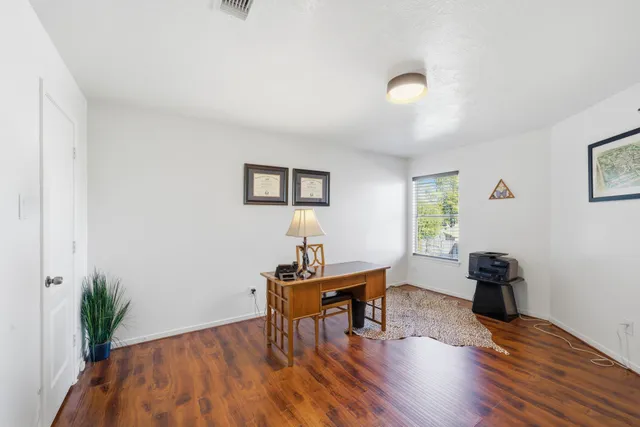 a view of a workspace with furniture and a window