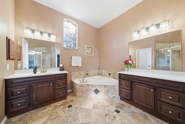 a spacious bathroom with a tub sink and mirror