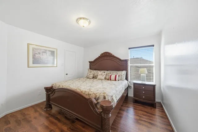 a bedroom with a bed a mirror and a window