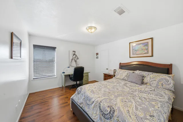 a bedroom with a bed and wooden floor