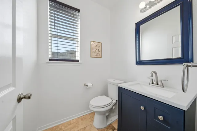 a bathroom with a toilet a sink a vanity and mirror