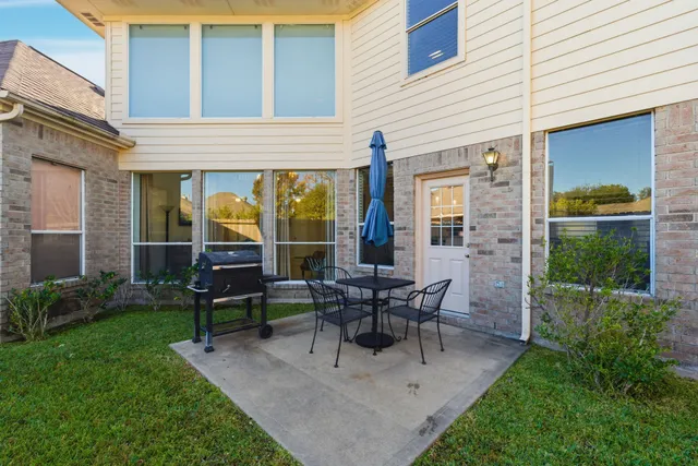 a view of a house with patio and a yard