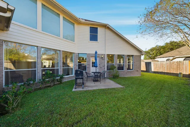a view of a backyard with table and chairs potted plants and a palm tree