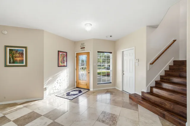 a view of an empty room with stairs and furniture