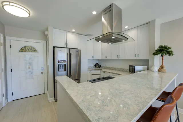 a kitchen with stainless steel appliances granite countertop a sink a stove and a refrigerator