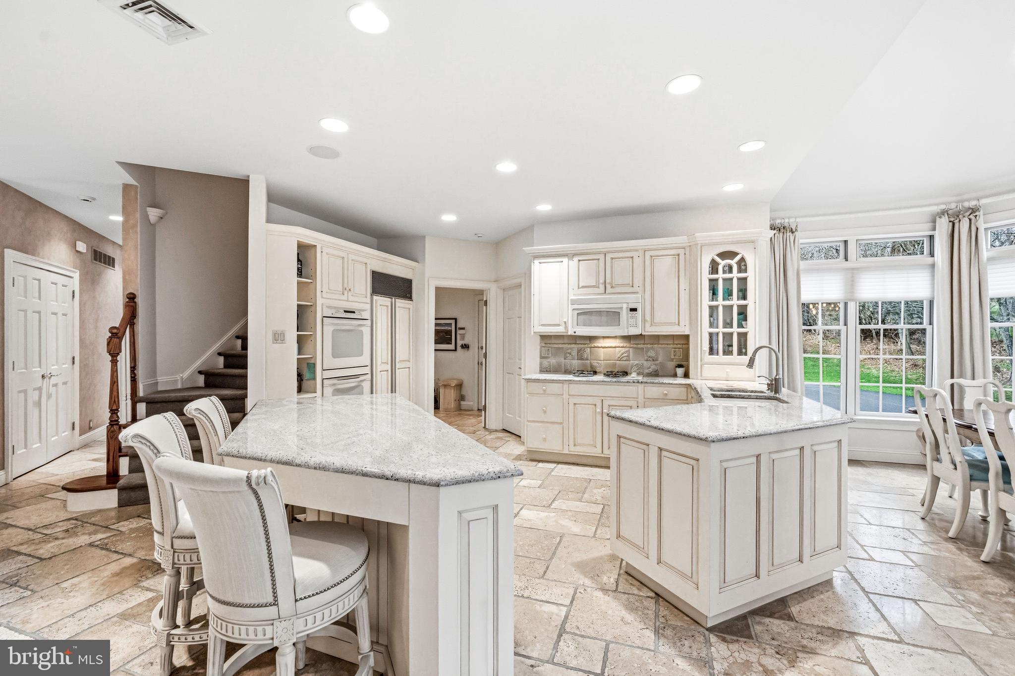 7 Mercer Gate Drive Doylestown, PA 18901 - Photo 13 of 44 a kitchen with stainless steel appliances granite countertop a table chairs and a refrigerator