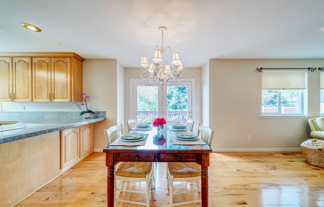 1273 Grayson Court Sandy, UT 84094 - Photo 11 of 27 Open-concept dining area featuring wood-finish flooring, a decorative chandelier, and abundant natural light