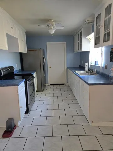 a kitchen with a sink a stove and a refrigerator