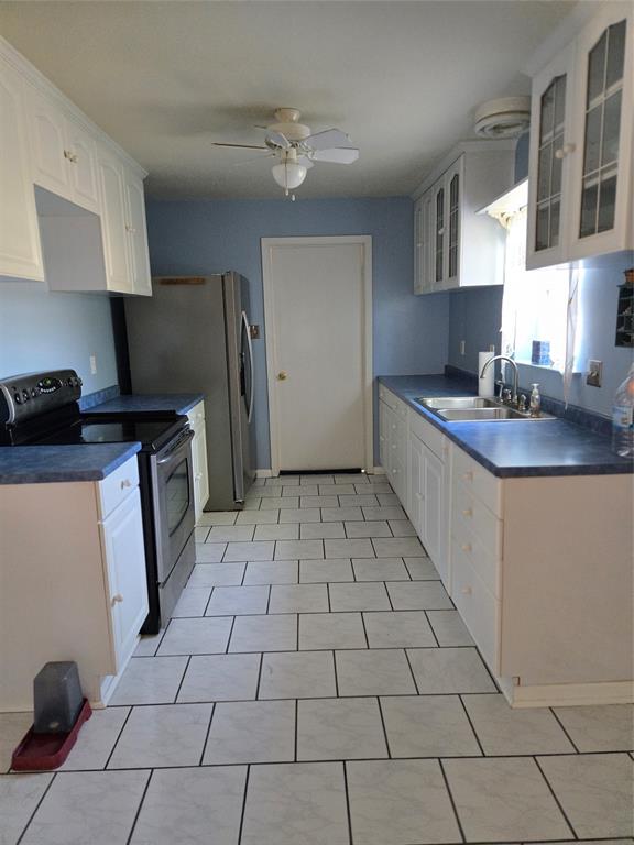 700 County Road 408 Comanche, TX 76442 - Photo 10 of 22 a kitchen with a sink a stove and a refrigerator