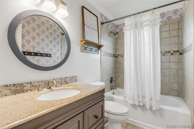 a bathroom with a granite countertop toilet a sink and a shower
