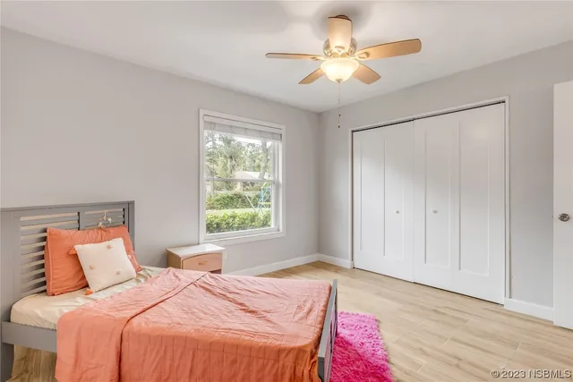 a bedroom with a large bed and a ceiling fan