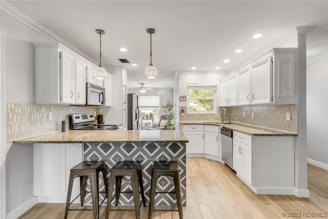 a kitchen with white cabinets stainless steel appliances and a center island