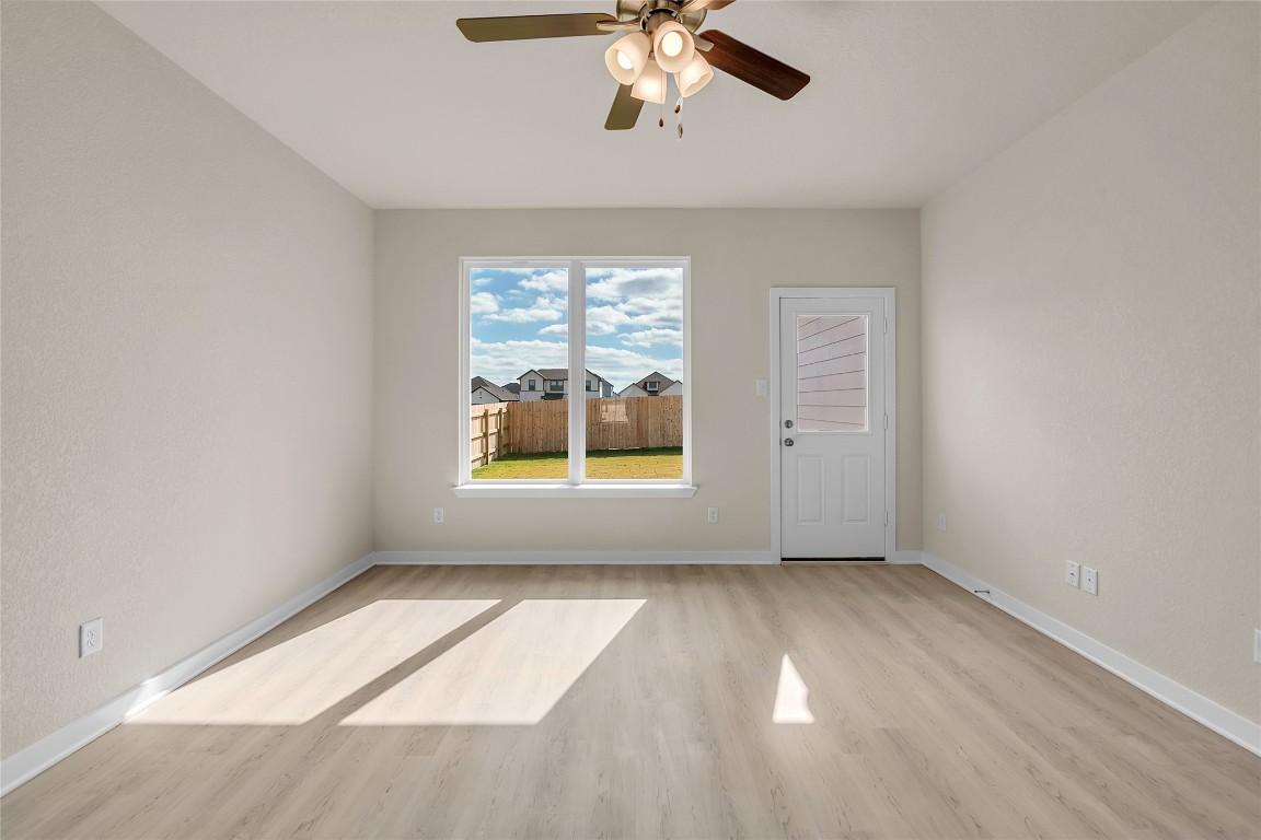 290 Boatright Boulevard Jarrell, TX 76537 - Photo 11 of 32 an empty room with windows and chandelier fan