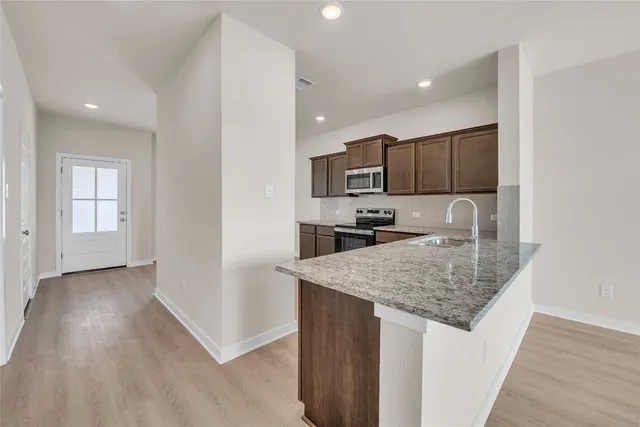 a kitchen with kitchen island sink refrigerator and stove