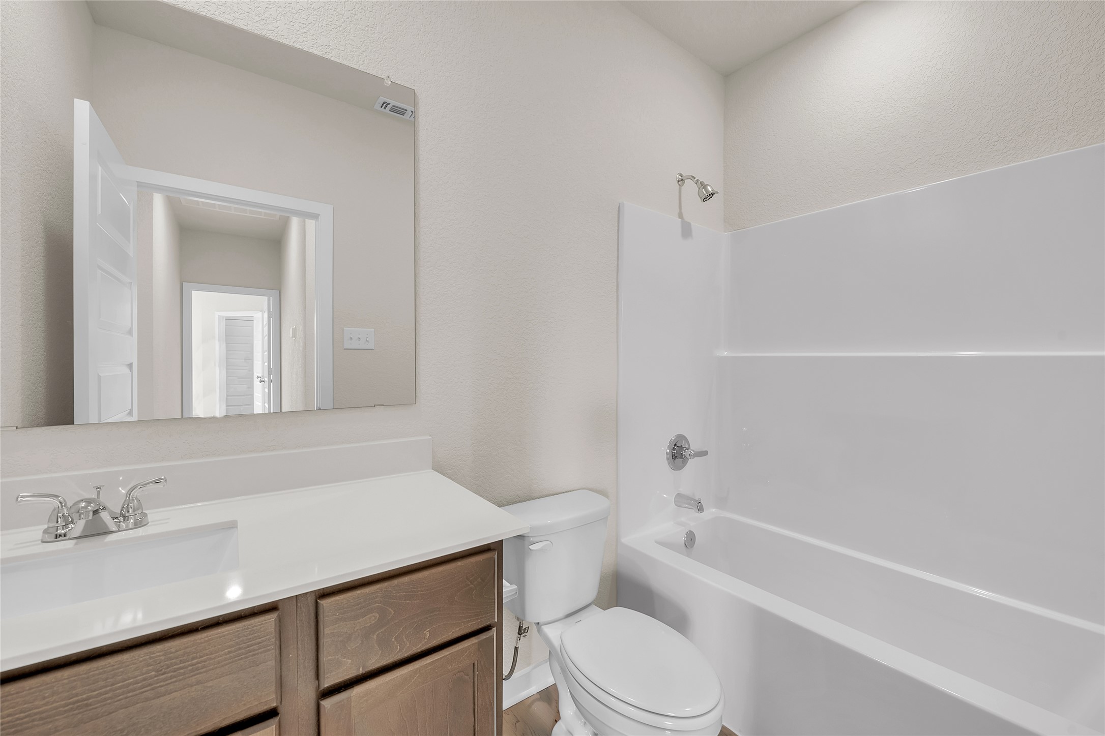 290 Boatright Boulevard Jarrell, TX 76537 - Photo 23 of 32 Bathroom featuring bathing tub / shower combination, vanity, and a textured wall
