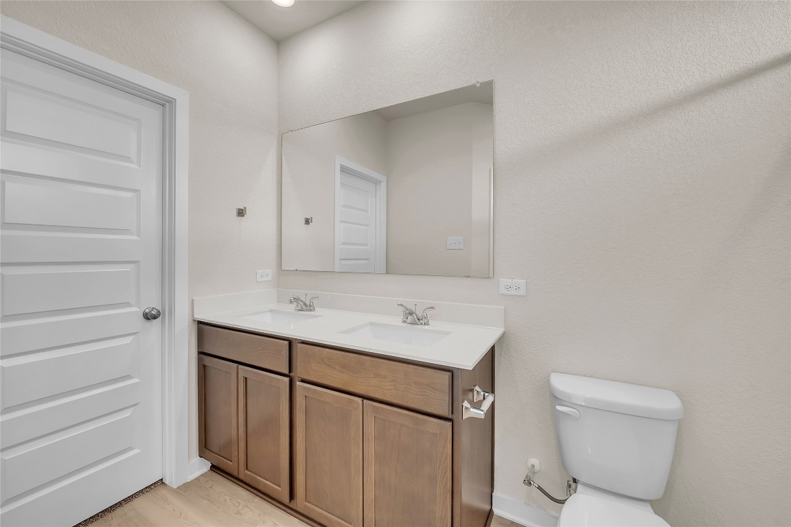 290 Boatright Boulevard Jarrell, TX 76537 - Photo 28 of 32 a bathroom with a sink a toilet and a mirror