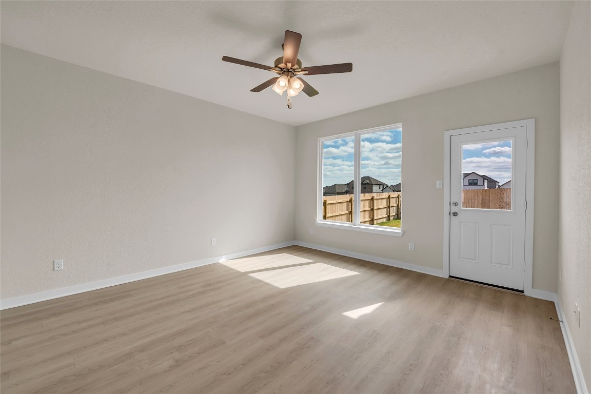 290 Boatright Boulevard Jarrell, TX 76537 - Photo 29 of 32 an empty room with wooden floor chandelier fan and windows