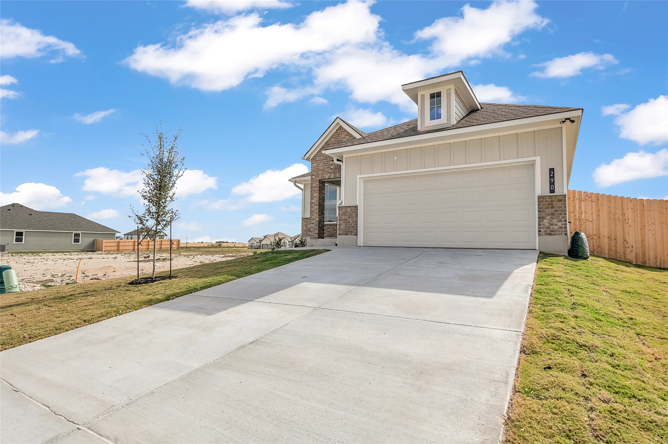 290 Boatright Boulevard Jarrell, TX 76537 - Photo 5 of 32 View of front of house featuring brick siding, board and batten siding, driveway, and an attached garage