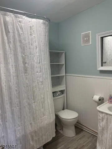 a bathroom with a toilet and a shower curtain