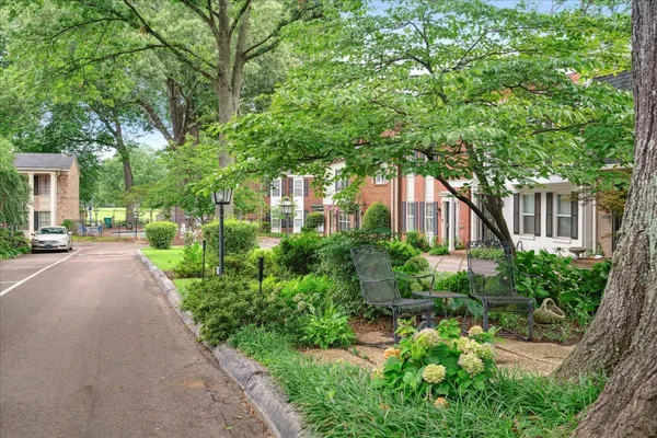 a front view of a house with a yard and shrubs