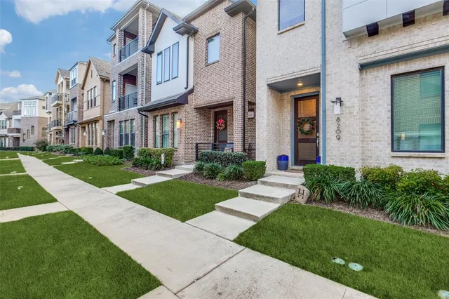 a front view of a brick house with a yard
