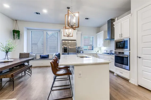 a kitchen with kitchen island granite countertop a sink counter top space appliances and cabinets