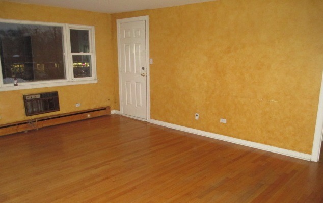 7858 Rutherford Avenue, Unit 2A Burbank, IL 60459 - Photo 5 of 10 a view of an empty room with wooden floor and a window