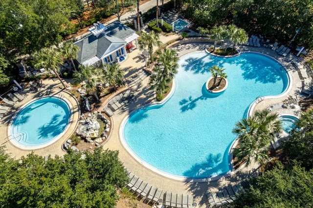 an aerial view of a house with swimming pool and outdoor seating