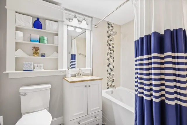a bathroom with a sink a toilet and shower curtain
