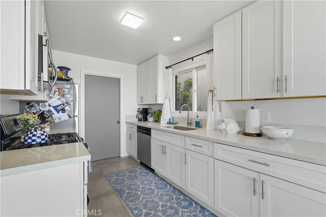 a kitchen with sink refrigerator and cabinets