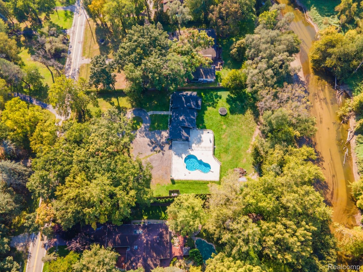 15879 Millar Road Clinton Township, MI 48036 - Photo 59 of 65 Property with an in-ground swimming pool, surrounded by mature trees and a manicured lawn